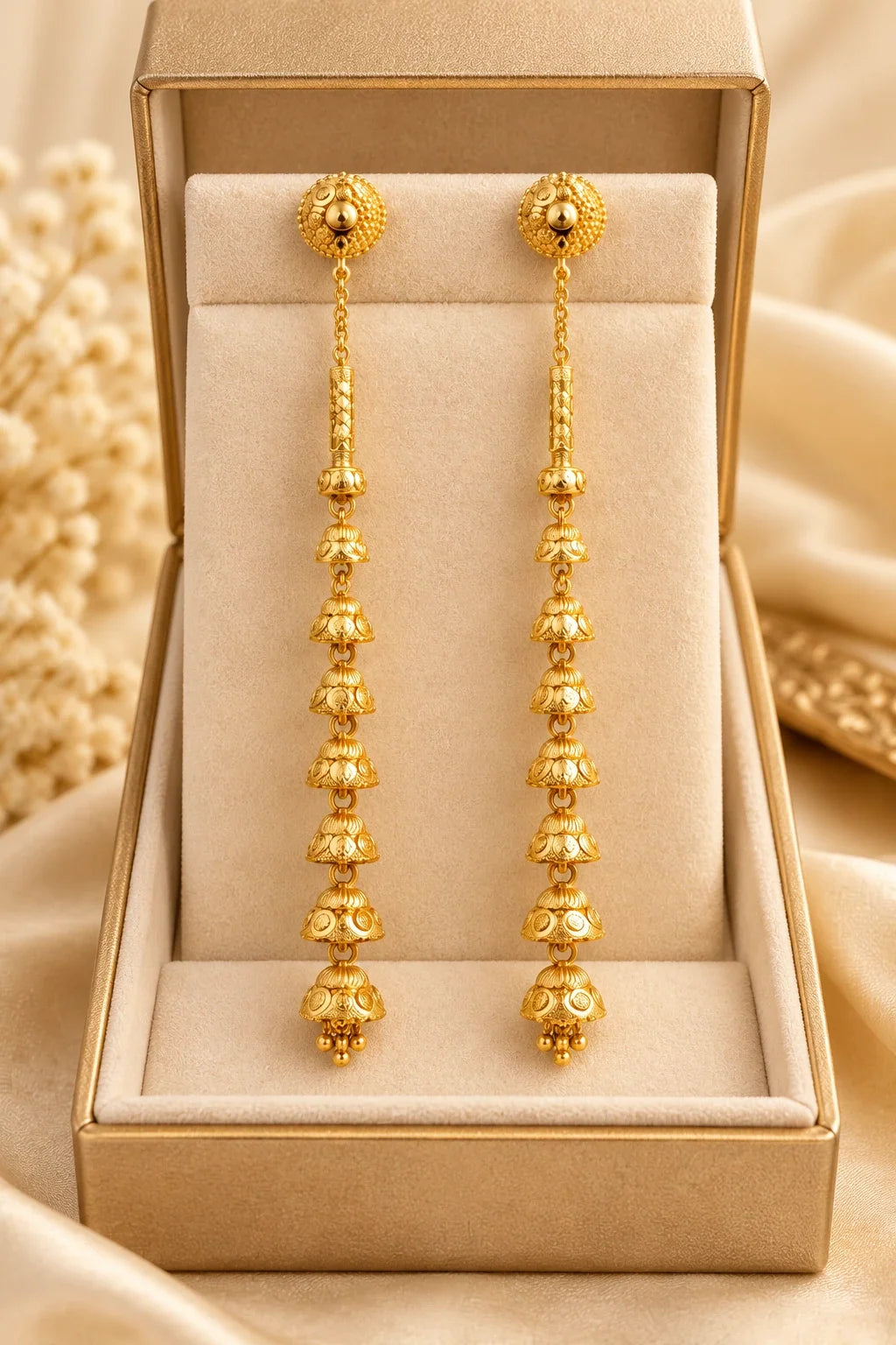 Long sui dhaga jhumka earrings in a gold jewellery box