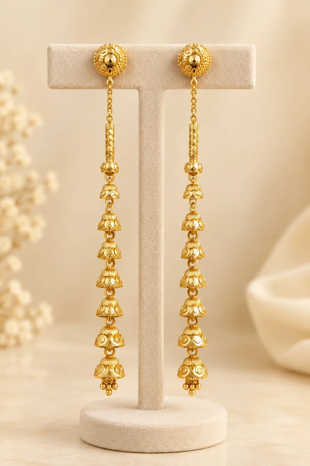 Long bell-drop jhumka earrings on a T-bar stand