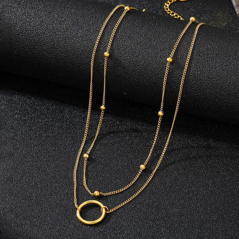 Beaded chain and hoop pendant laid over black fabric