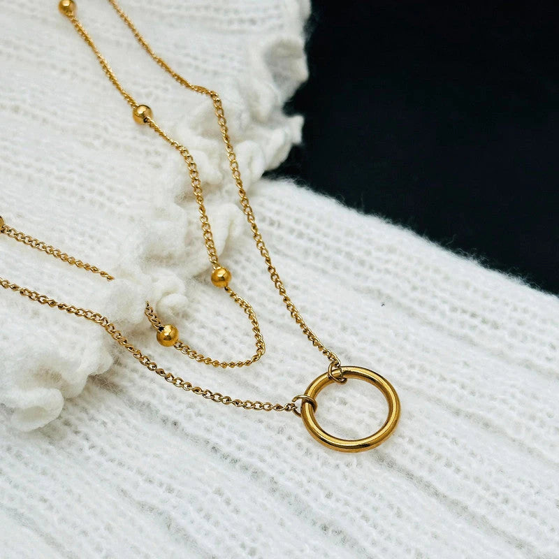 Hoop pendant and beaded chain on white knit fabric