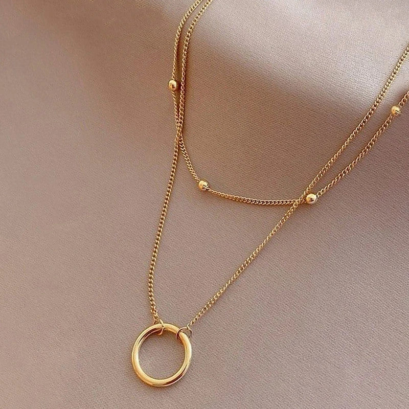 Close-up of the beaded strand and open hoop worn on the neck