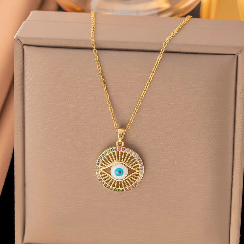 Evil eye sunburst pendant on its chain over a beige gift box