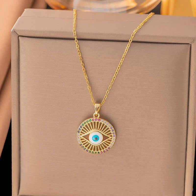 Evil eye sunburst pendant on its chain over a beige gift box