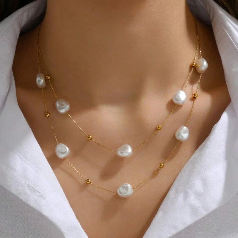 Two-layer pearl necklace worn with an open white collar