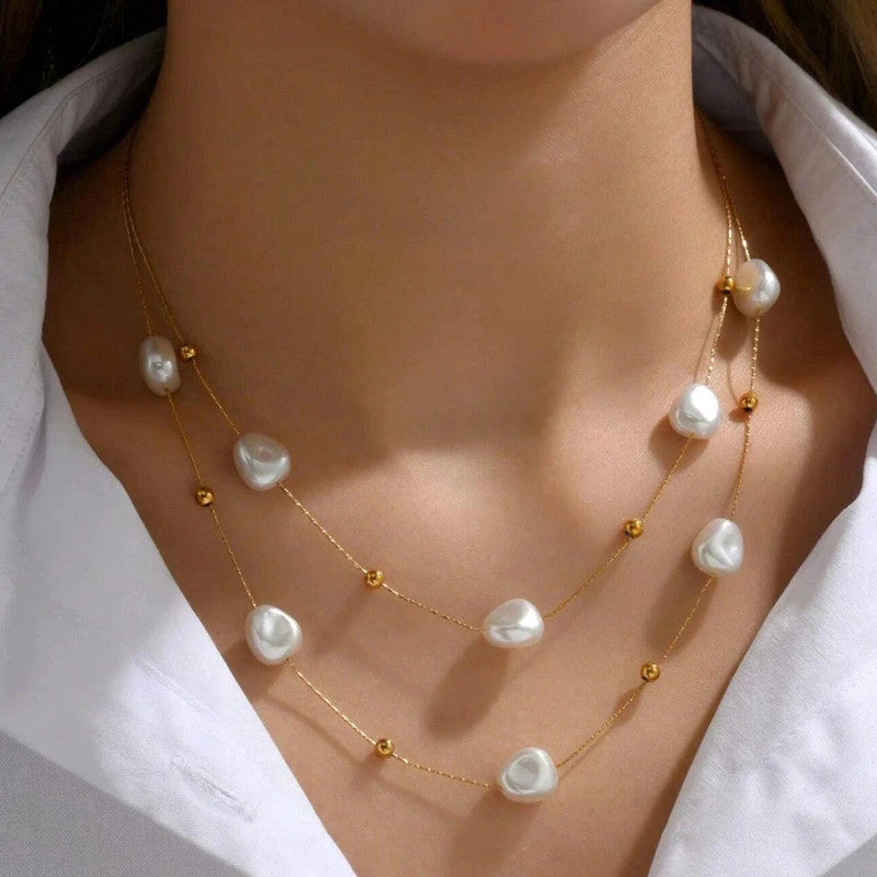 Close-up of both pearl strands worn at the collarbone