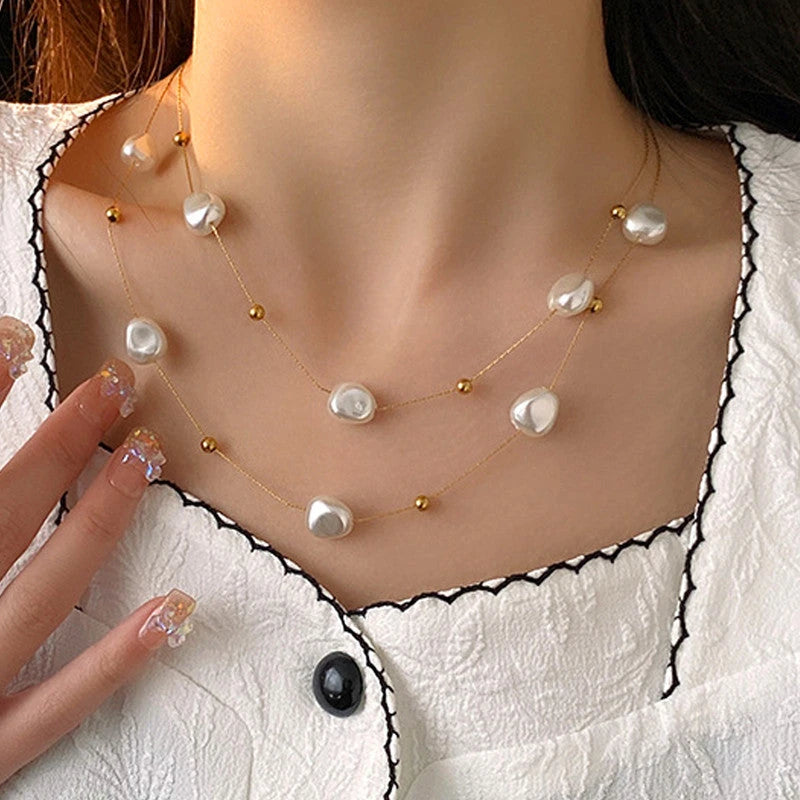 Two-layer pearl necklace worn with a white blouse with black trim