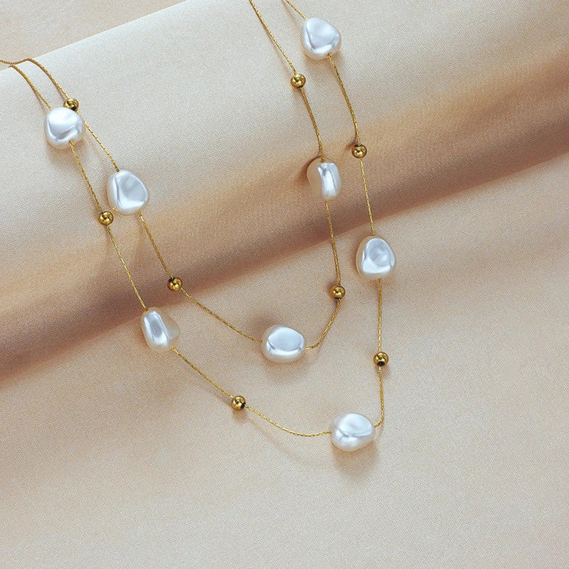 Pearl beads and gold beads on fine chains over cream satin
