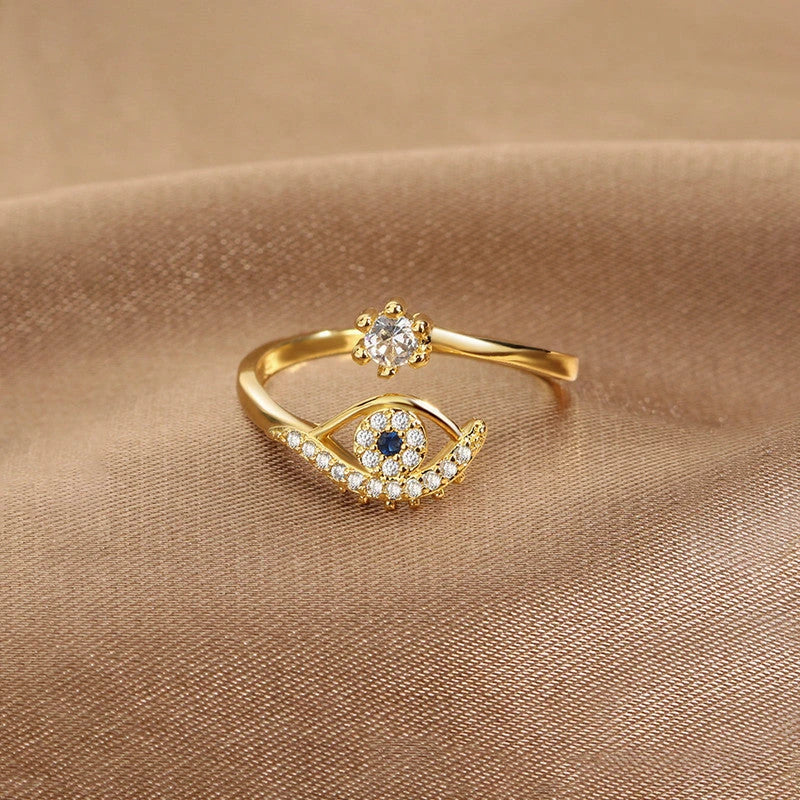 Evil eye open ring with clear stones on beige fabric
