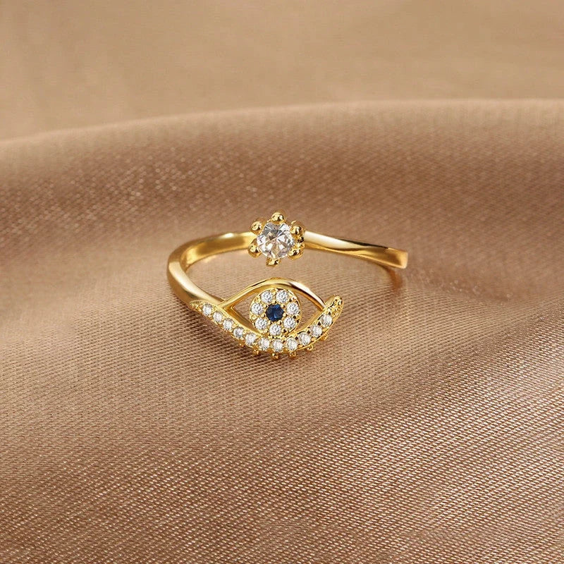 Evil eye open ring with clear stones on beige fabric