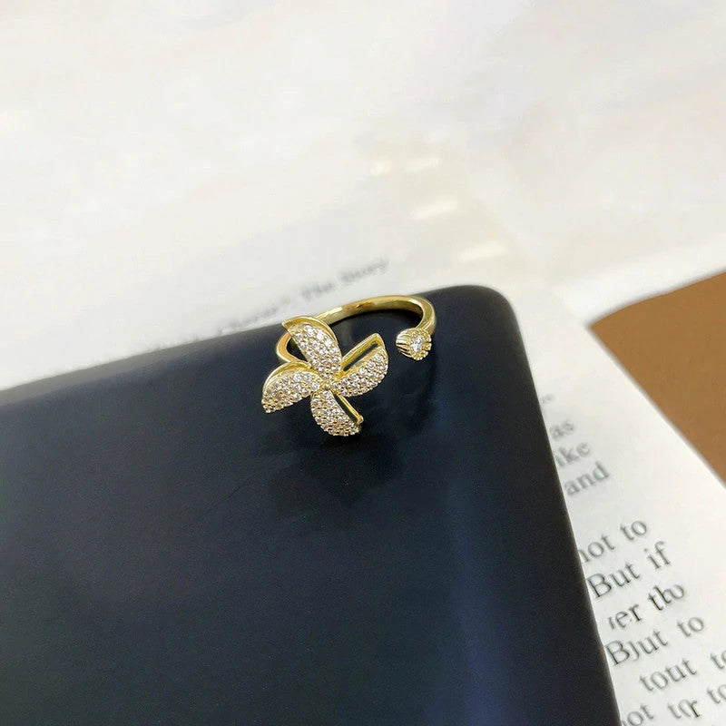 Pinwheel ring with clear stones on a dark box