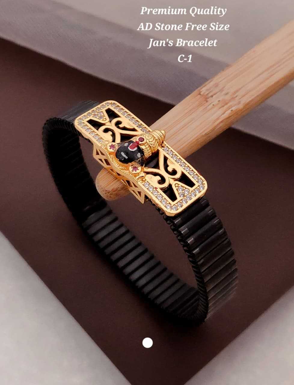 Design A: black enamel deity face on a gold-tone CZ plate